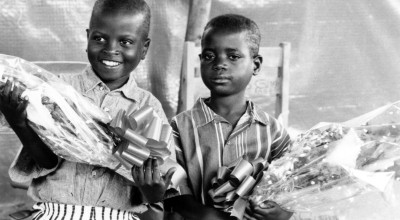 Two children hold flowers at the Runda transition camp in Rwanda. Photo: Concern Worldwide (1997)