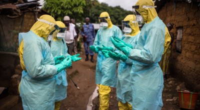A burial team pray before they collect a corpse from inside a house in the east of Freetown Sierra Leone in 2015 Ebola outbreak. Photograph: Michael Duff