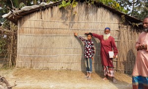Community members in Vati Kapasia, Kapasia Union, Sundarganj, Bangladesh show the level of the flood water from the 2019 monsoon on their home. Photo: Finola Mohan / Concern Worldwide.