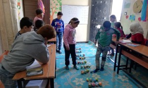 Children enrolled in the non-formal education (NFE) programme in the 'Make Math Fun' class in Northern Syria, January 2020. This is part of the numeracy sessions to learn multiplication using small coloured balls.