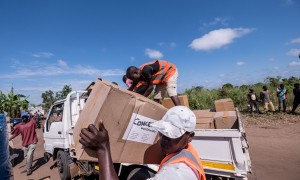 Workers unload kitchen kits from a truck at a distribution in Ndeja, Mozambique, which was hard hit by cyclone Idai in March 2019. Photo: Tommy Trenchard / Concern Worldwide.