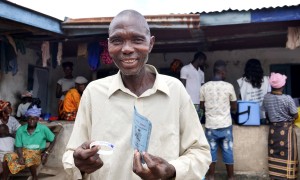 Victor S Canteh (46) holds his vaccination card after receiving his second vaccination in Madif. 'I am very glad I was able to get my second dose.’ Photo: Conor O'Donovan / Concern Worldwide.