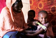 Halima Bare measures her  child Iqra Hassan's mid upper arm circumference (MUAC),